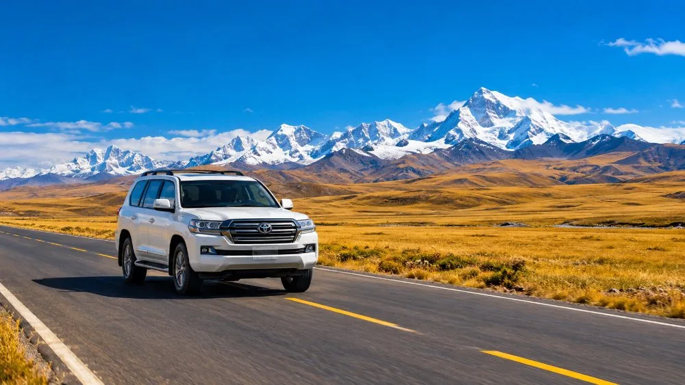 Ein Land Cruiser auf der leeren Autobahn über das tibetische Hochplateau in Richtung Himalaya