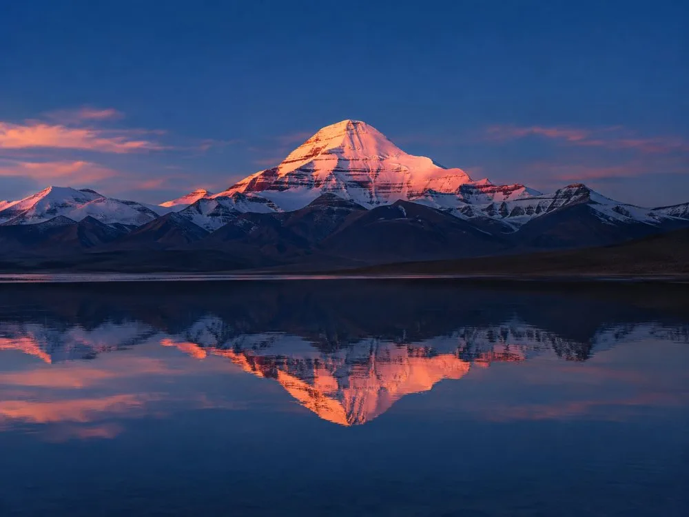 Sonnenaufgang auf der schneebedeckten Spitze des Mount Kailash, gesehen über dem See Manasarovar